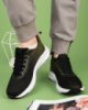 Жіночі чорно-зелені кросівки з текстилю.