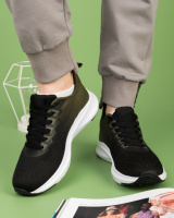 Жіночі чорно-зелені кросівки з текстилю.